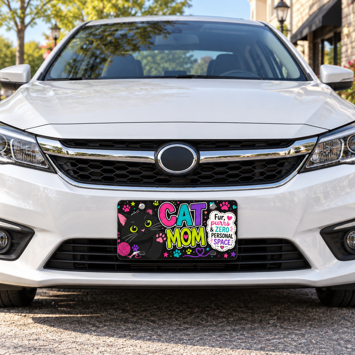 Cat Mom decorative license plate mounted on white car in bright daytime setting