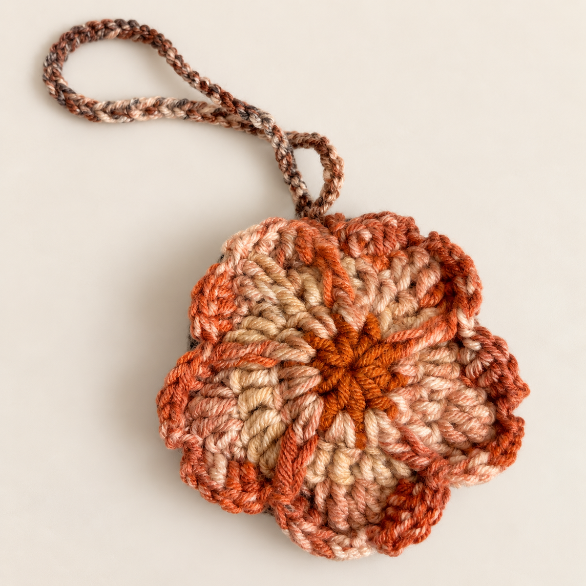 Back view of handmade charcoal and rust flower crochet pouch