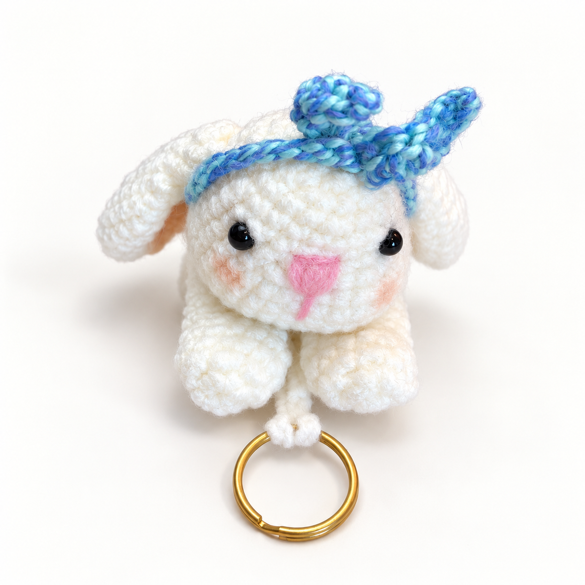 Close front view of handmade white crochet bunny key holder with blue variegated headband