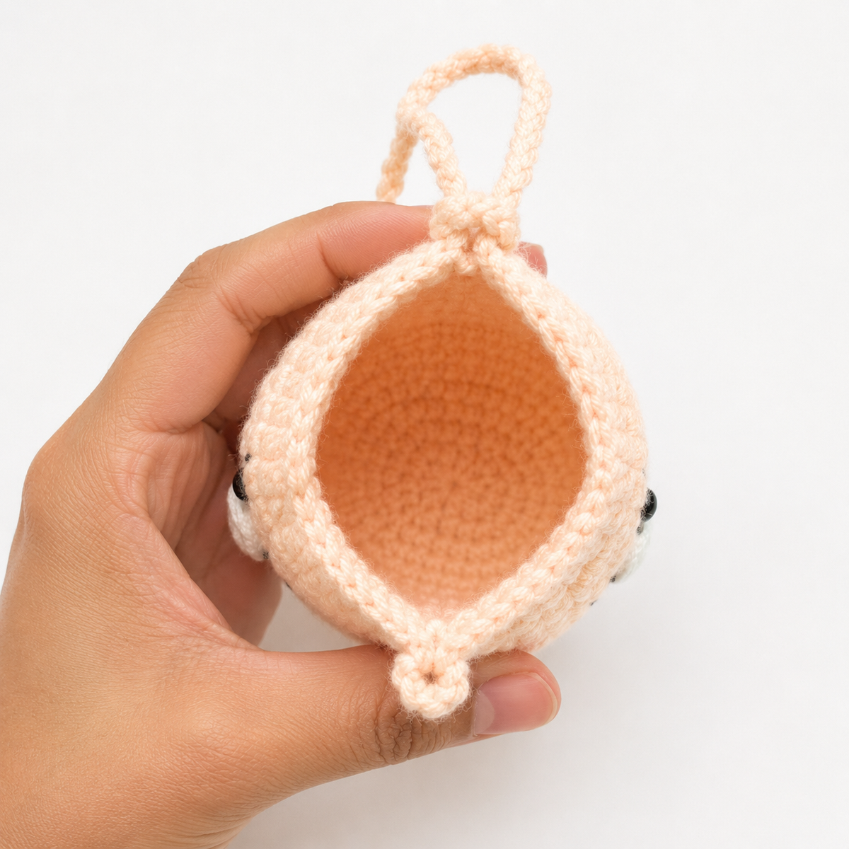 Open handmade peach crochet cat mini pouch showing empty unlined interior