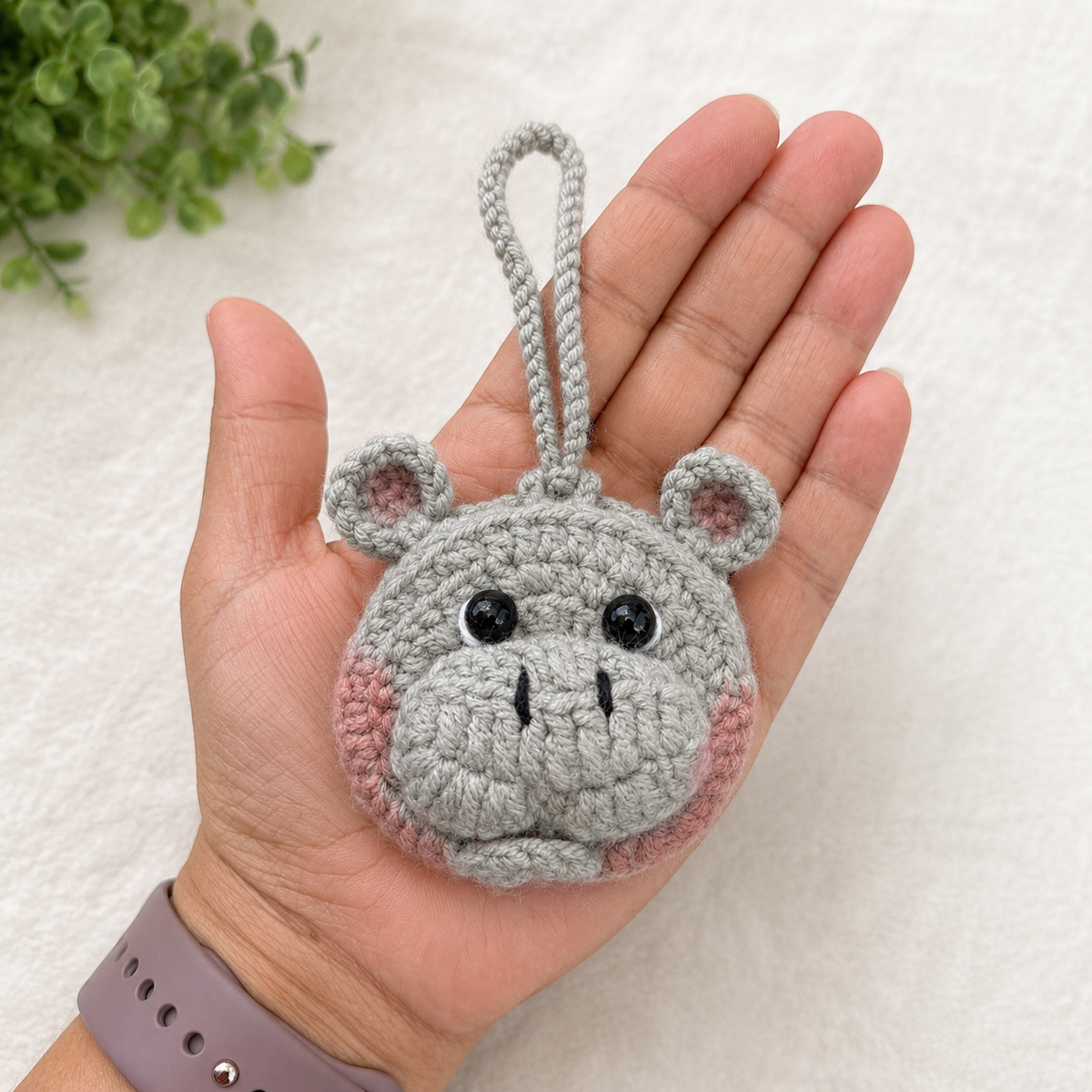 Handmade gray crochet hippo mini pouch shown in hand for size