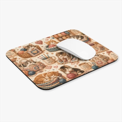 Angled view of crochet kittens mouse pad with white computer mouse