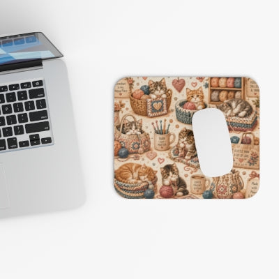 Crochet kittens mouse pad beside laptop with computer mouse