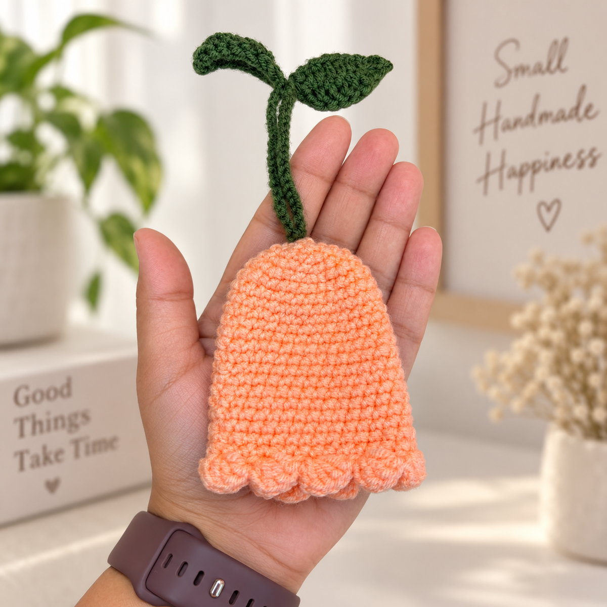 Peach crochet flower key holder shown in hand for size reference