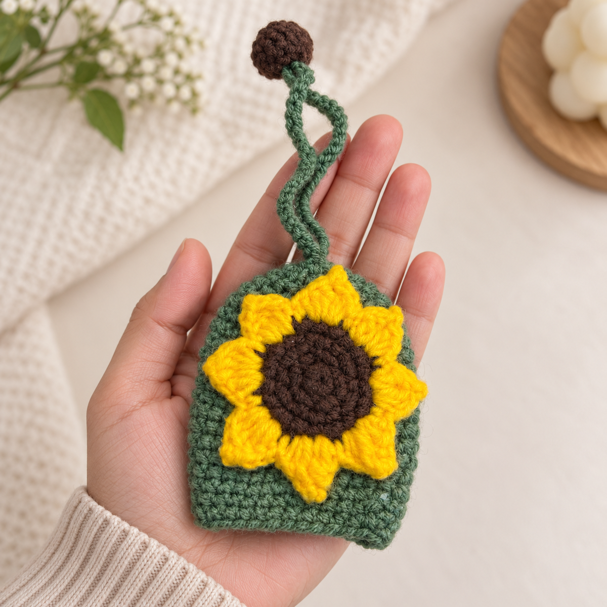 Sunflower crochet key holder shown in hand for size reference