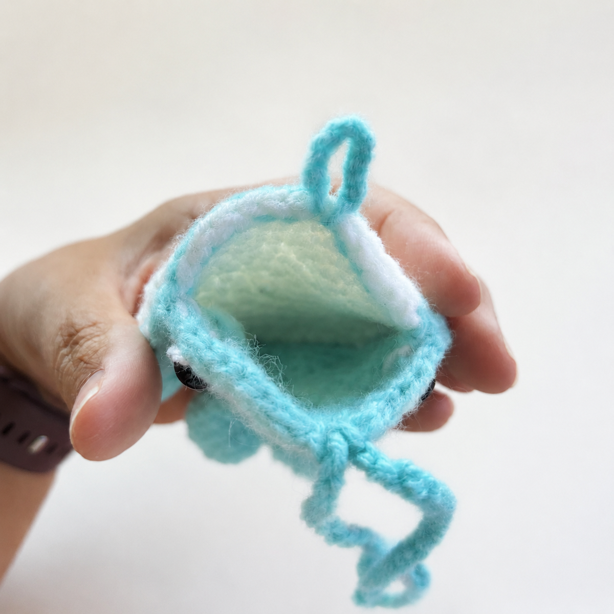 Open handmade crochet whale pouch showing unlined interior