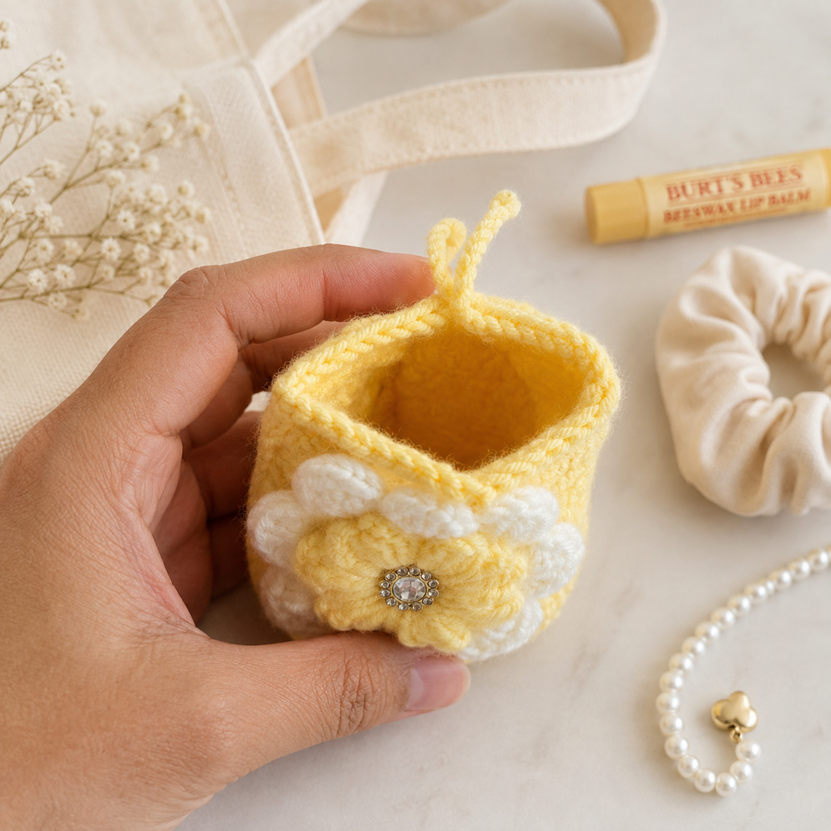 Open handmade yellow crochet flower mini pouch in a lifestyle setting