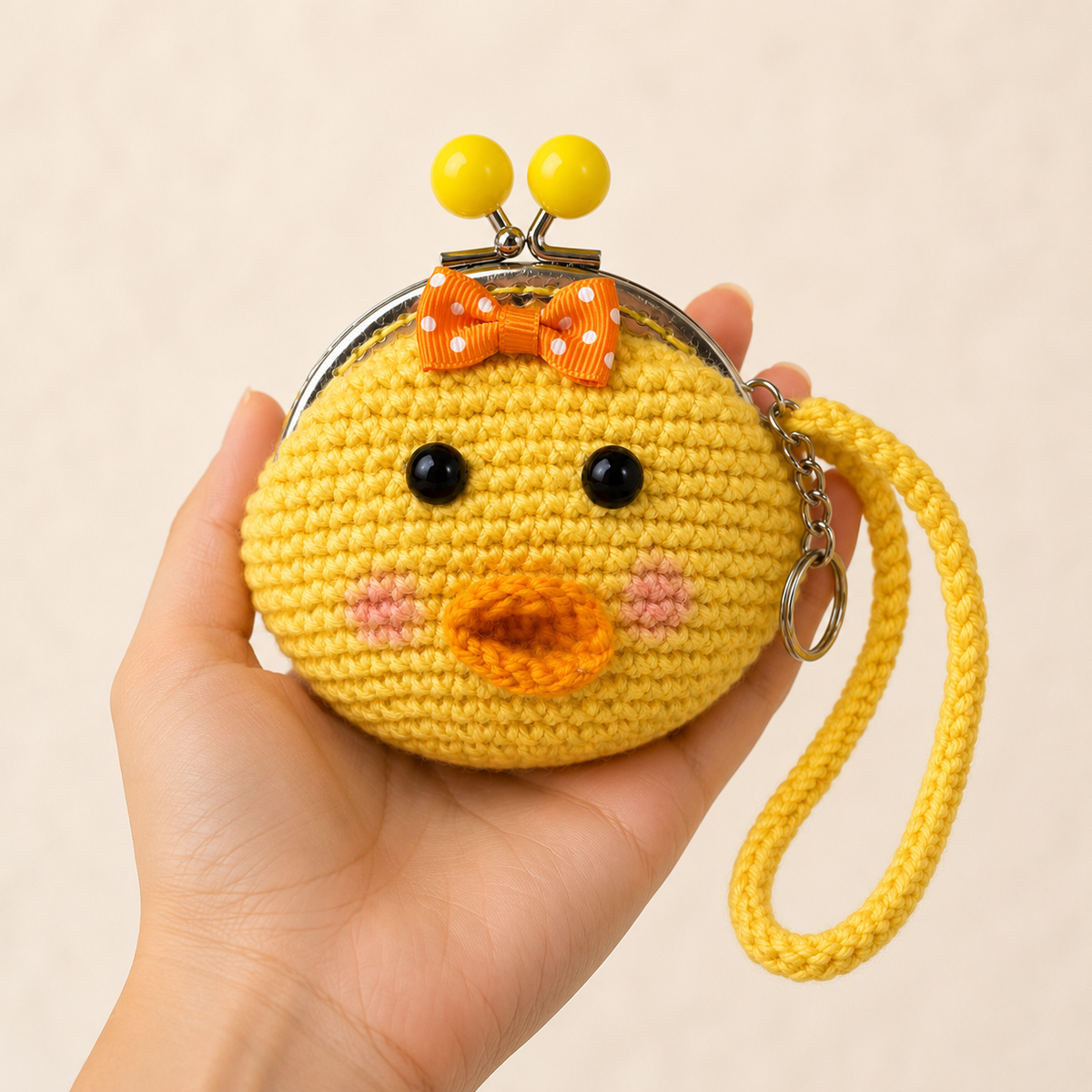 Yellow crochet duck coin purse held in hand for scale