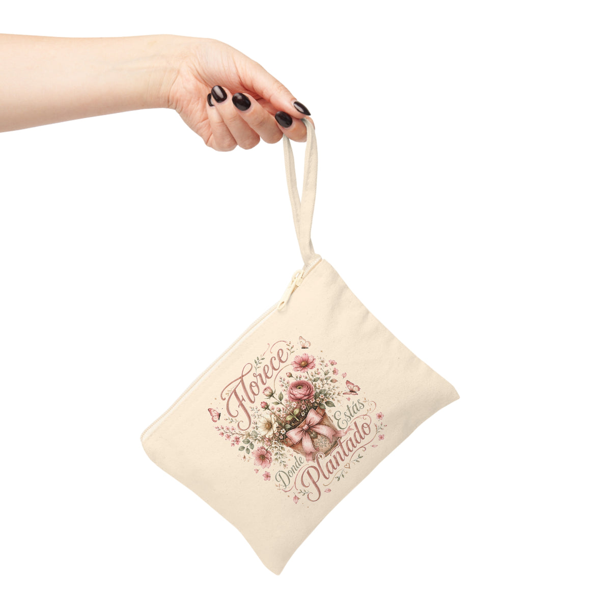 Florece Donde Estás Plantado canvas wristlet pouch shown hanging by its strap with a pink floral and butterfly design.