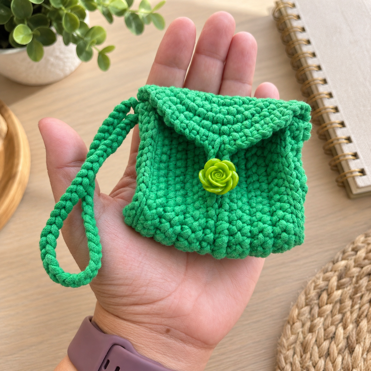 Green Rose Crochet Wristlet Pouch shown in hand for size reference
