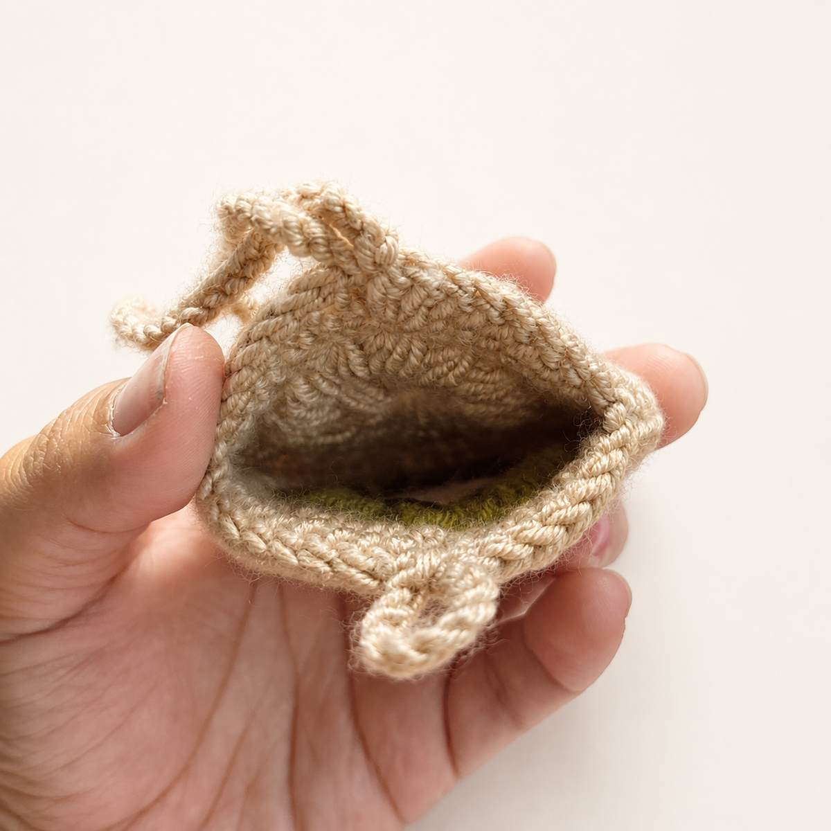 Open handmade crochet kiwi mini pouch showing unlined interior