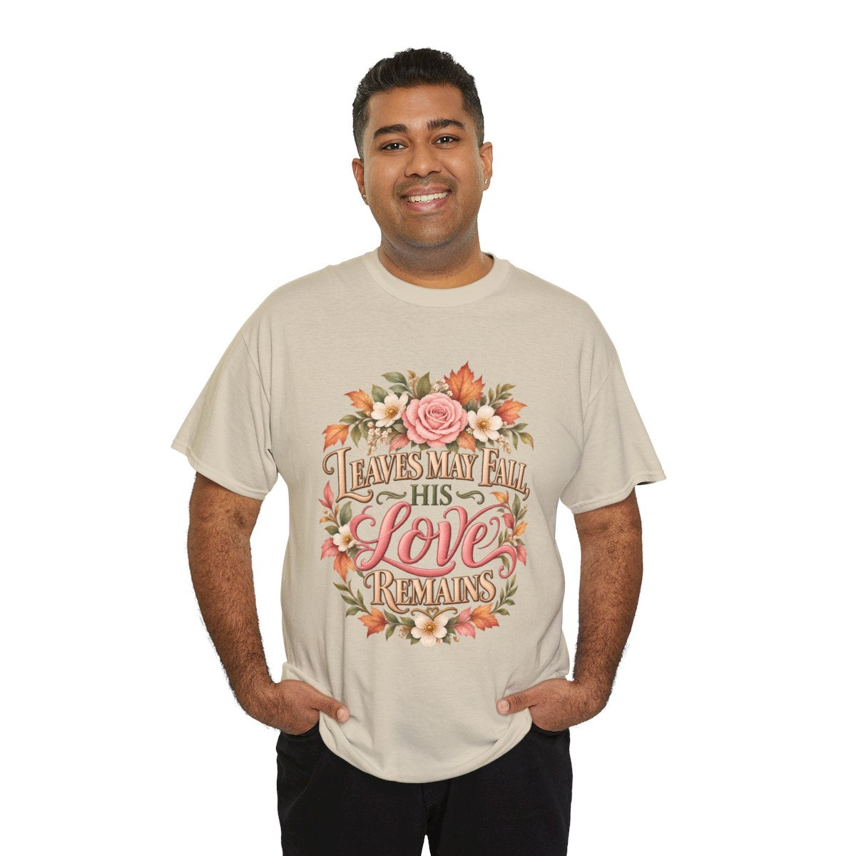 Man wearing the Leaves May Fall His Love Remains T-shirt in sand