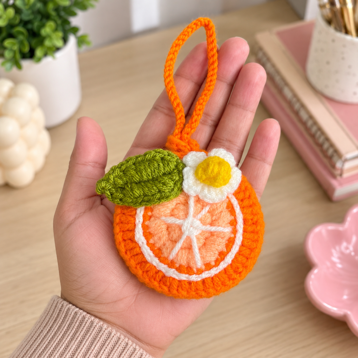 Orange crochet mini pouch shown in hand for size reference