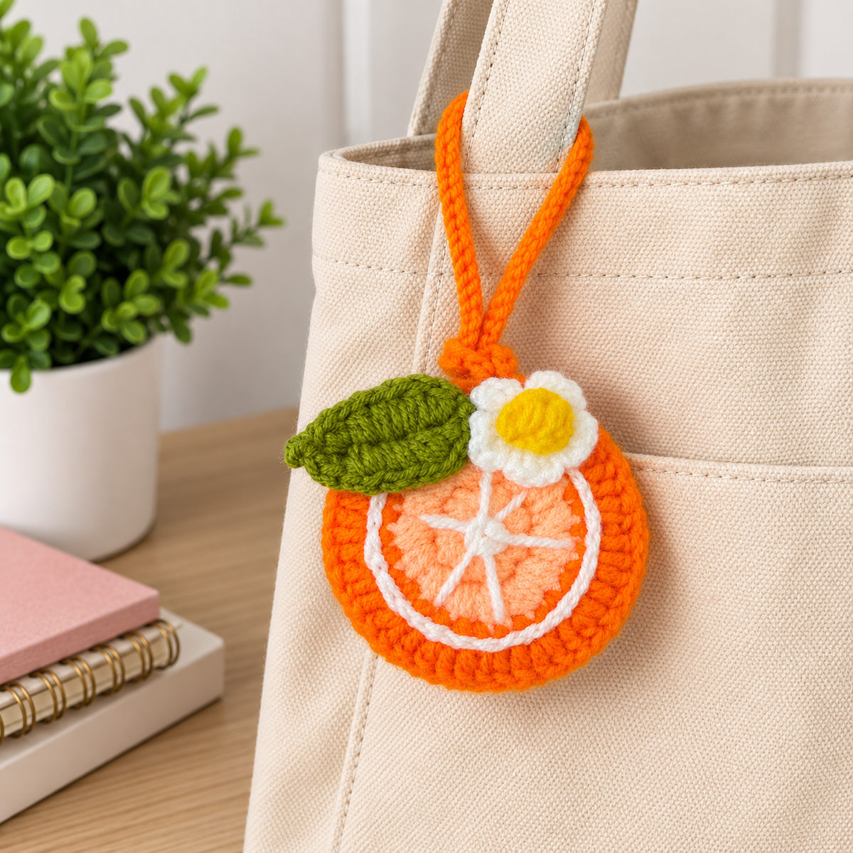 Orange crochet mini pouch bag charm attached to canvas tote