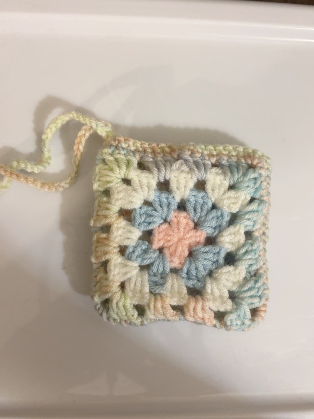 Back view of handmade pastel granny square crochet pouch