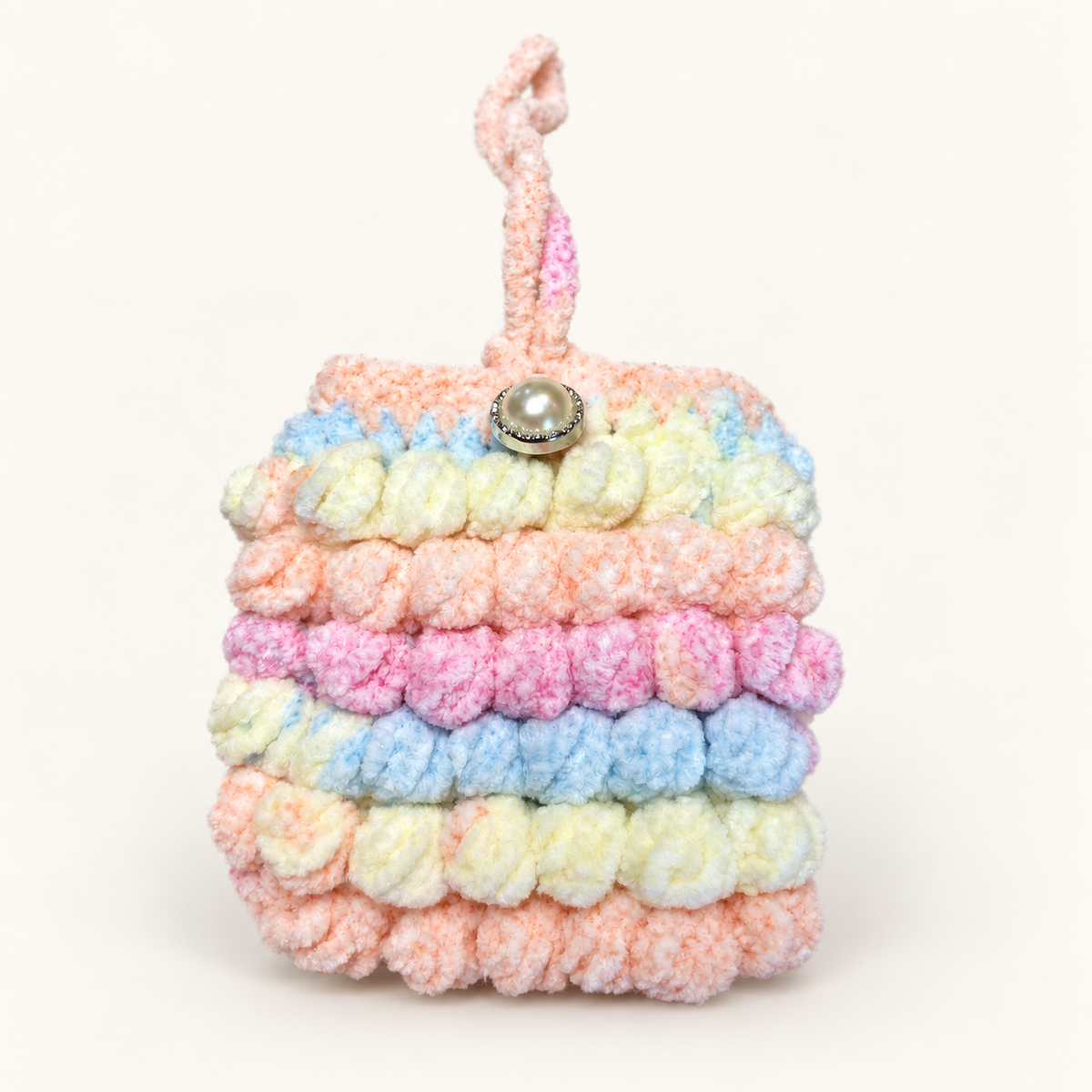 Front view of handmade pastel ruffle crochet mini pouch with pearl-style button