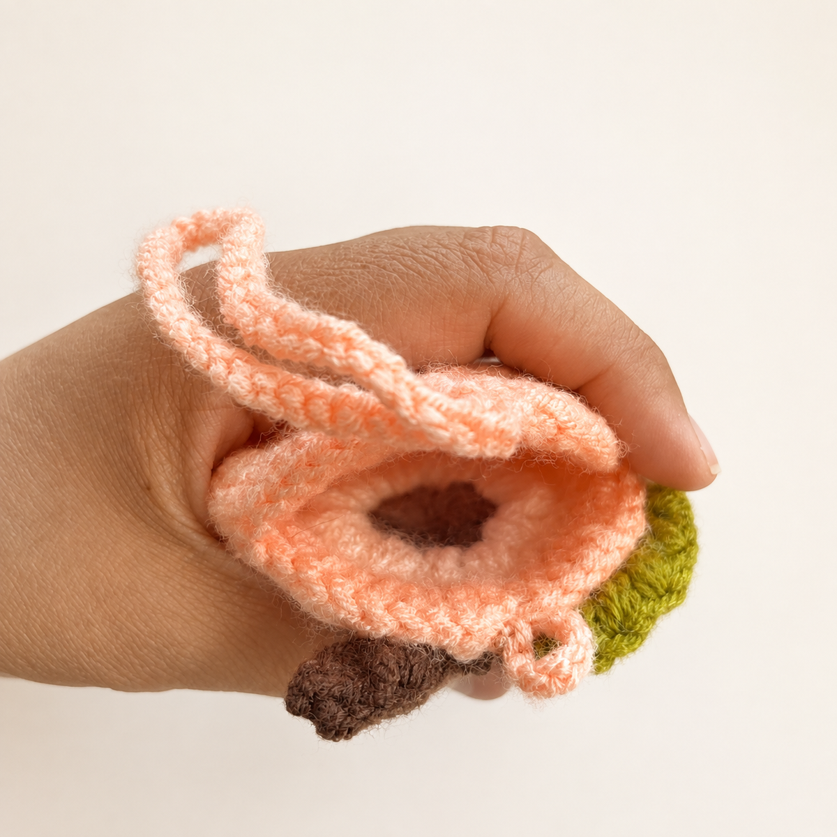 Open handmade crochet peach mini pouch showing unlined interior