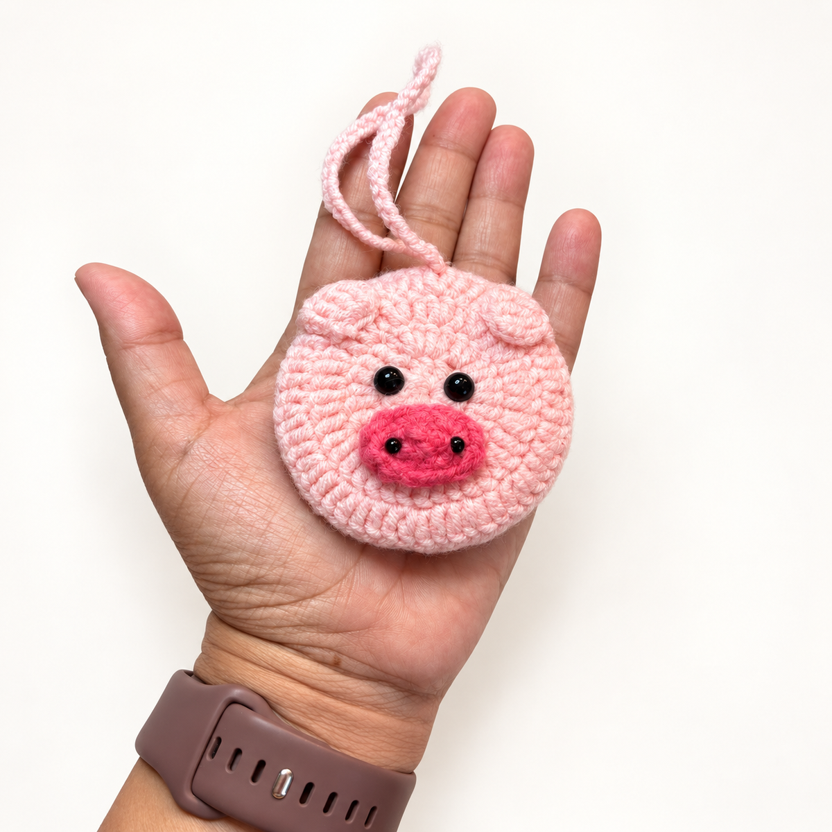 Pink pig crochet pocket mirror shown in hand for size reference