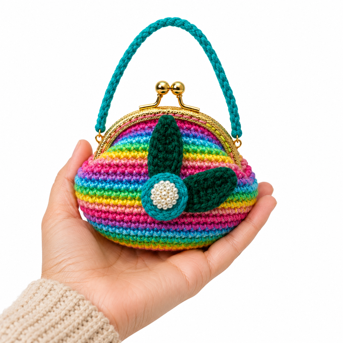 Rainbow crochet floral coin purse held in one hand for scale