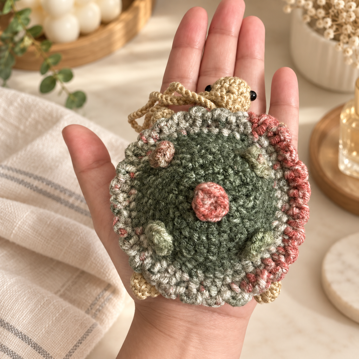 Sage crochet turtle pocket mirror charm shown in hand for approximate five-inch scale